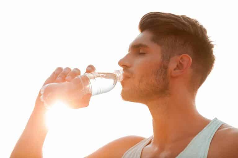 Młody mężczyzna pije wodę